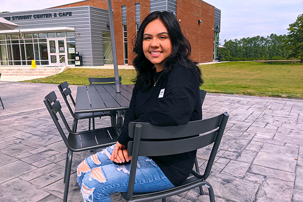 Student sitting in a chair on the patio