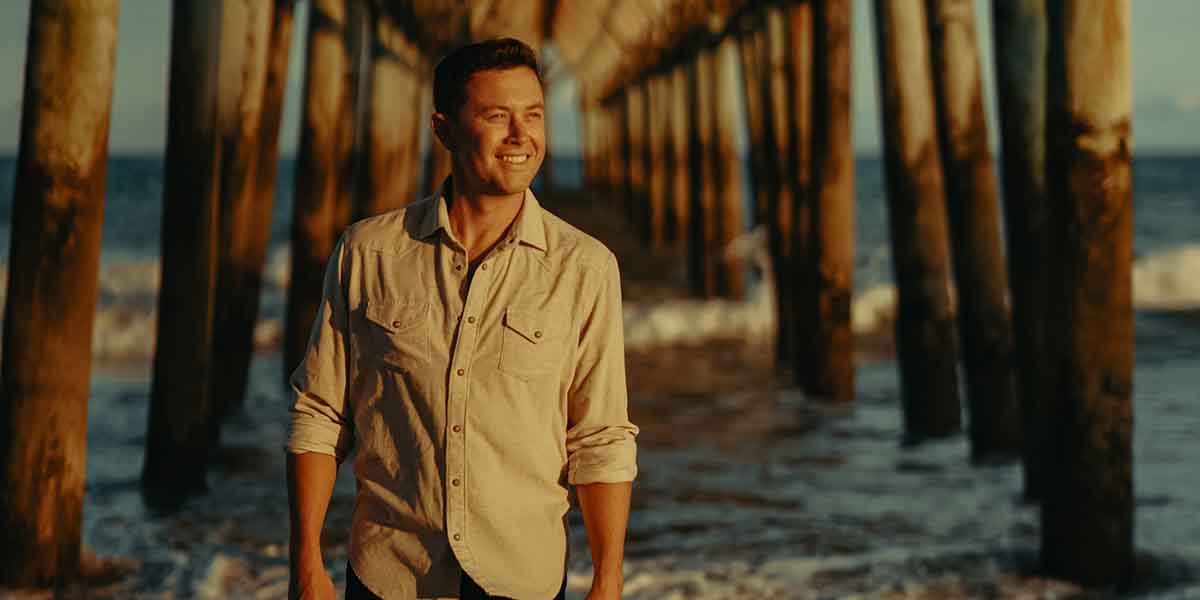 Scotty McCreery walks under the pier at the beach