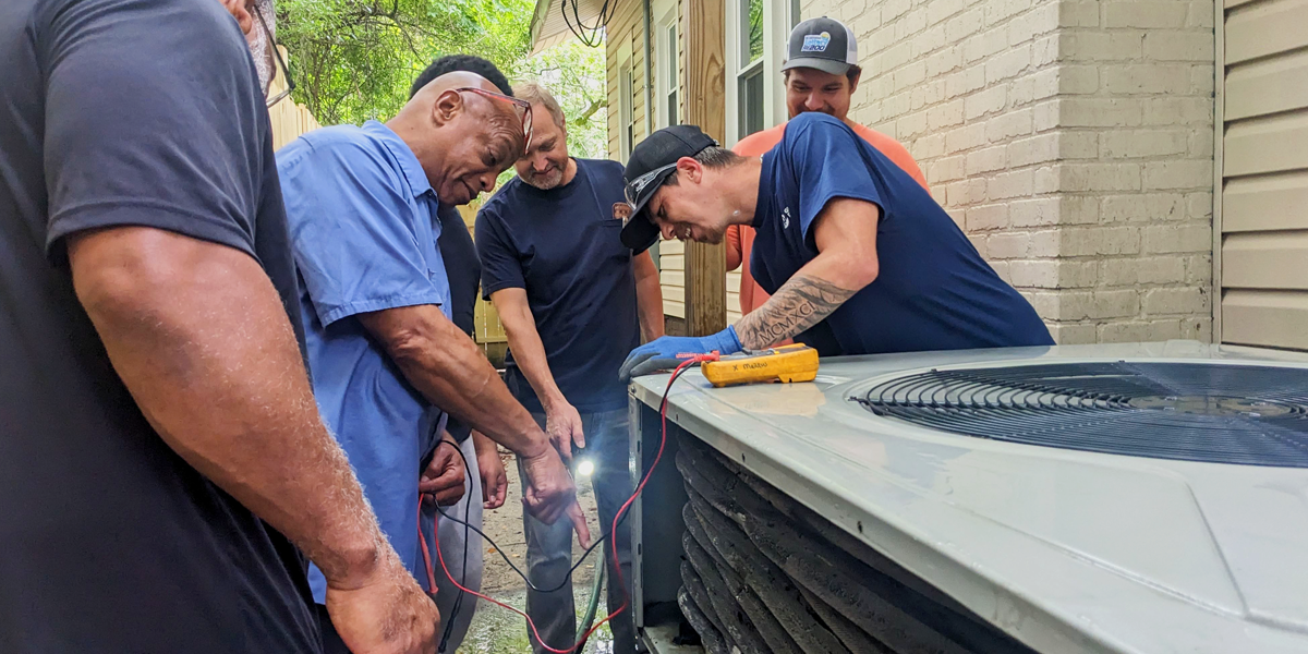 NCCER HVAC Instructor Marcus X working with his students on a residential air conditioning system