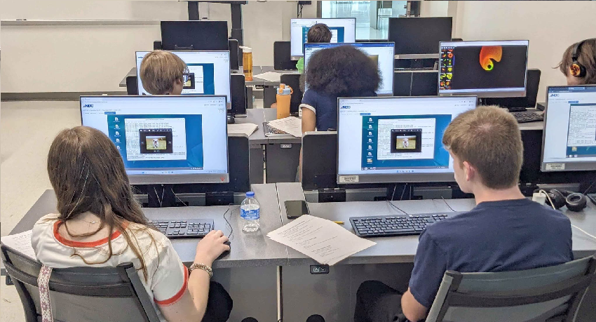 Students sit at a computer during the Hack it Up summer Camp