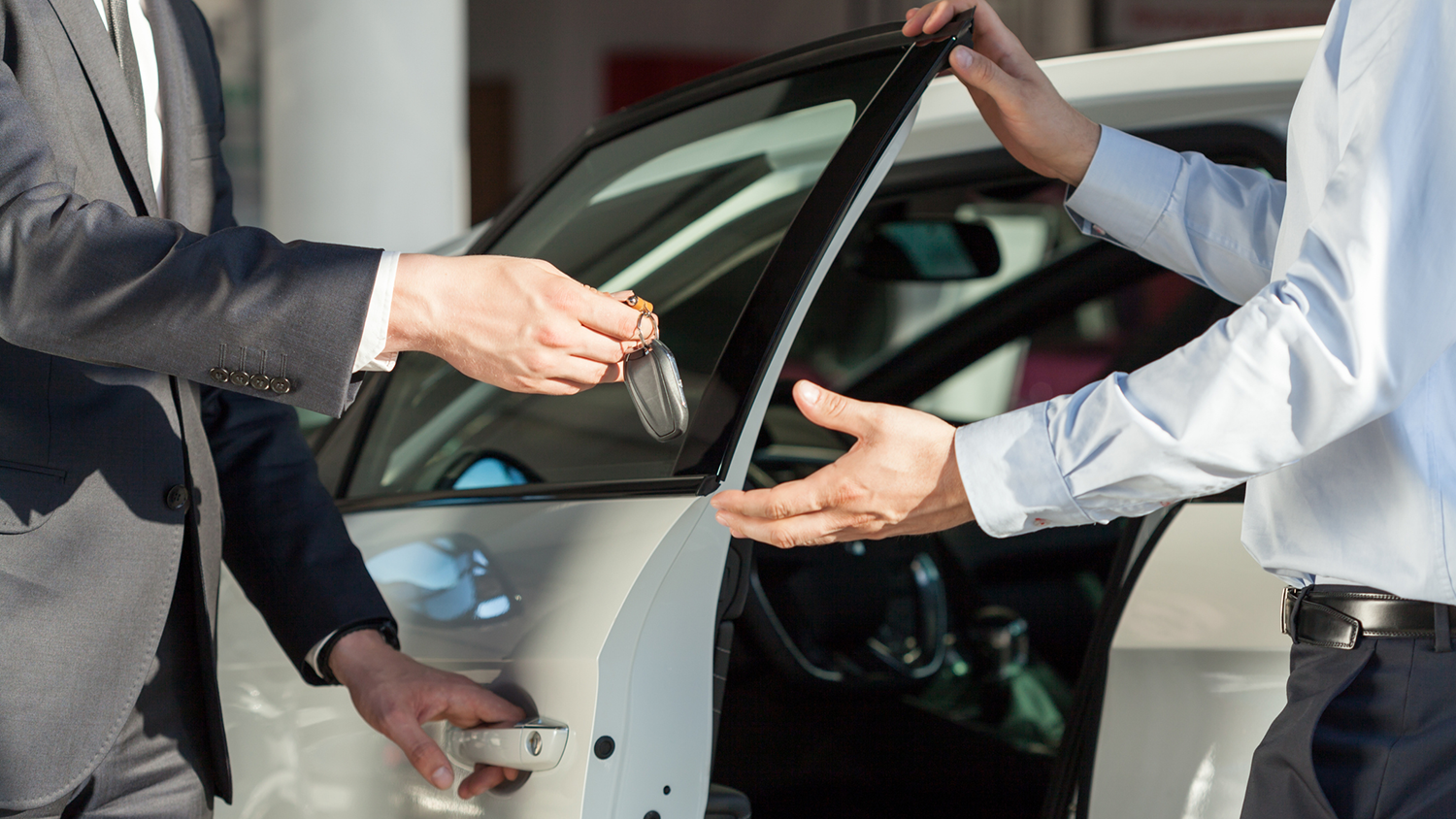 Car dealer passing off keys to a customer